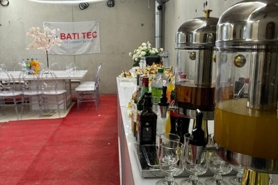 Assiette de burrata garnie de tomates cerises colorées et décorée d'une fleur violette sur une table blanche.