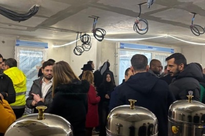 Assiette de burrata garnie de tomates cerises colorées et décorée d'une fleur violette sur une table blanche.