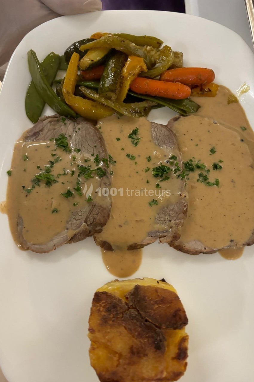 Assiette contenant trois tranches de viande en sauce, légumes sautés et un gratin individuel.