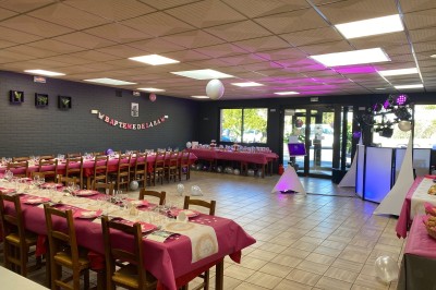 Miniature Location salle Maretz (Nord) - California #3 Salle avec un bar en bois, décorée de briques apparentes, tonneaux et une table haute ornée de fleurs blanches.