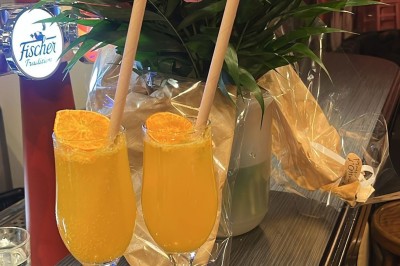 Fresque murale représentant des mains tenant une fleur avec un œil, entourée de papillons et de motifs floraux.