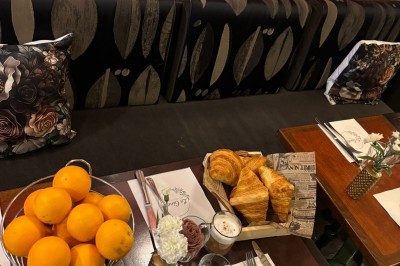 Fresque murale représentant des mains tenant une fleur avec un œil, entourée de papillons et de motifs floraux.