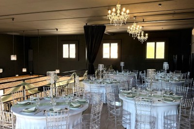 Coiffeuse en bois avec miroir éclairé, chaise grise et mur en pierre décorative en arrière-plan.