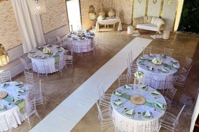 Coiffeuse en bois avec miroir éclairé, chaise grise et mur en pierre décorative en arrière-plan.