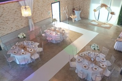 Coiffeuse en bois avec miroir éclairé, chaise grise et mur en pierre décorative en arrière-plan.