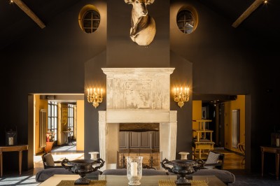 Salle de bain moderne avec lavabo sur plan en bois, miroir éclairé et douche à paroi en marbre noir.