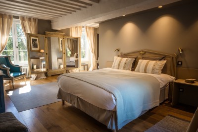 Salle de bain moderne avec lavabo sur plan en bois, miroir éclairé et douche à paroi en marbre noir.