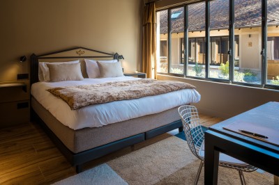 Salle de bain moderne avec lavabo sur plan en bois, miroir éclairé et douche à paroi en marbre noir.