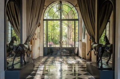 Salle de bain moderne avec lavabo sur plan en bois, miroir éclairé et douche à paroi en marbre noir.
