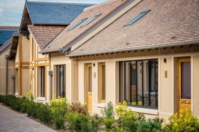 Salle de bain moderne avec lavabo sur plan en bois, miroir éclairé et douche à paroi en marbre noir.
