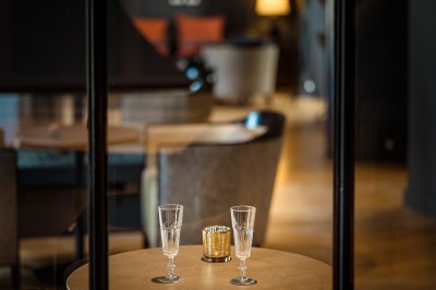 Salle de bain moderne avec lavabo sur plan en bois, miroir éclairé et douche à paroi en marbre noir.