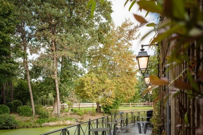 Salle de bain moderne avec lavabo sur plan en bois, miroir éclairé et douche à paroi en marbre noir.