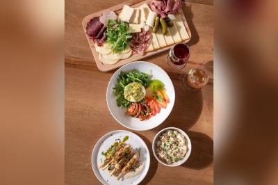 Miniature Location salle Asnières-sur-Seine (Hauts-de-Seine) - La Halle Flachat #17 Assiette contenant une salade colorée avec tomates, roquette et fromage coupé à l'aide d'un couteau et d'une fourchette.