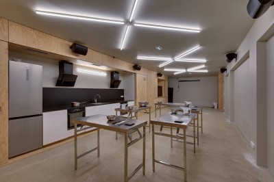 Miniature Location salle Asnières-sur-Seine (Hauts-de-Seine) - La Halle Flachat #15 Assiette contenant une salade colorée avec tomates, roquette et fromage coupé à l'aide d'un couteau et d'une fourchette.