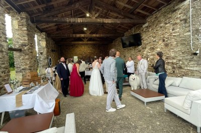 Miniature Location salle Vouvant (Vendée) - Le Hameau de Vouvant #5 Groupe de personnes debout dans une salle en pierre avec des lumières suspendues au plafond.