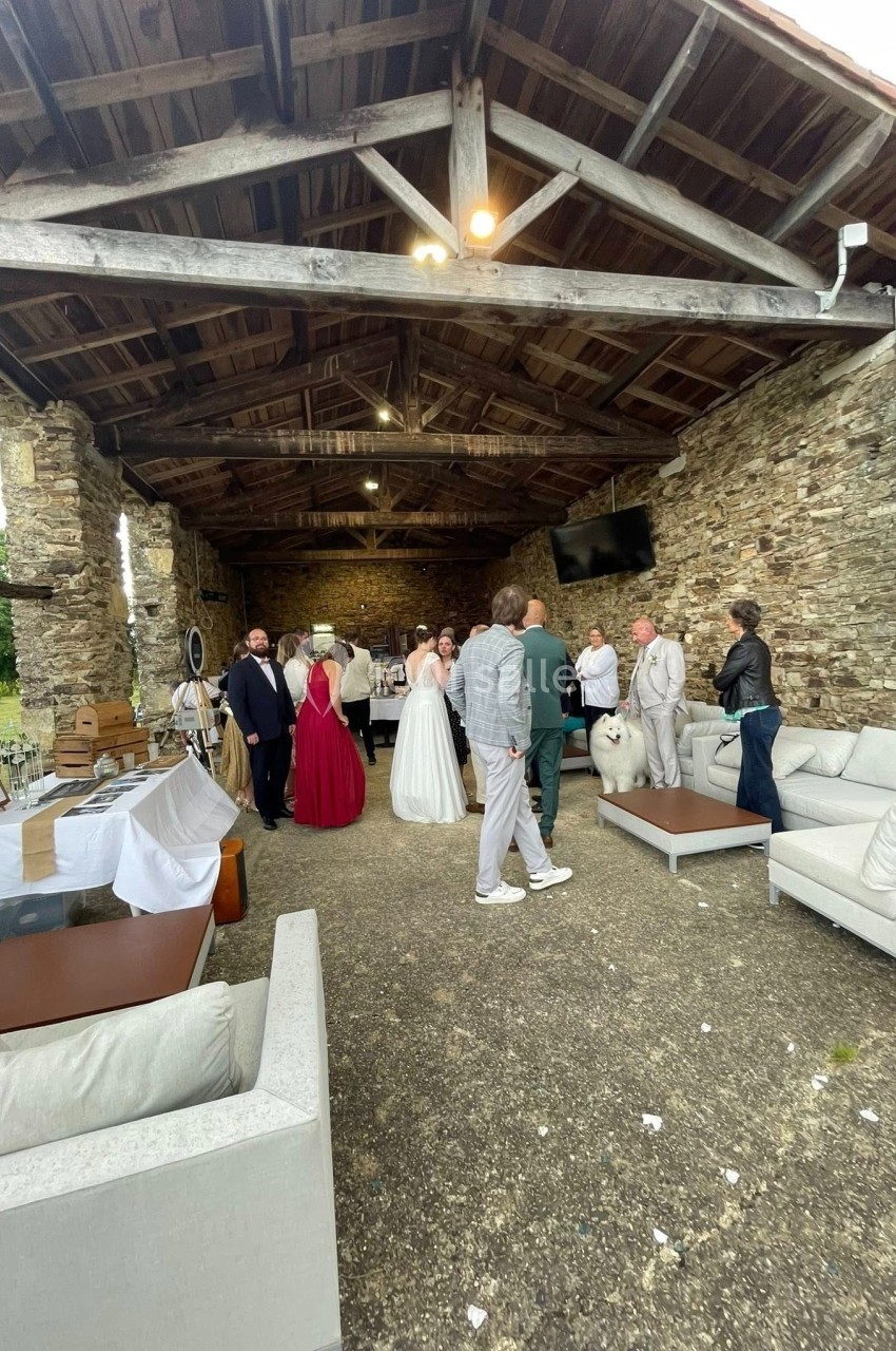 Groupe de personnes rassemblées dans un espace couvert en pierre, lors d'un événement festif.