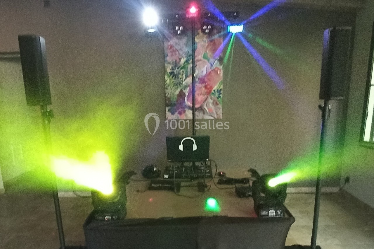 Installation de matériel de sonorisation et d'éclairage avec projecteurs colorés dans une salle intérieure.