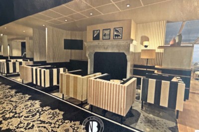 Façade d'un bâtiment clair avec terrasse, escalier en pierre et mobilier extérieur sous un ciel dégagé.