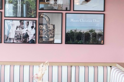 Bureau en bois clair avec une chaise, une machine à café, des tasses et une lampe murale allumée dans une chambre.