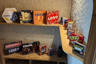Escalier en bois avec rambarde, dans un intérieur aux murs blancs texturés et sol en carrelage.