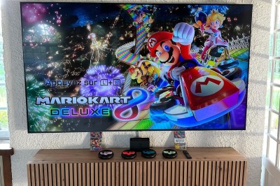 Escalier en bois avec rambarde, dans un intérieur aux murs blancs texturés et sol en carrelage.