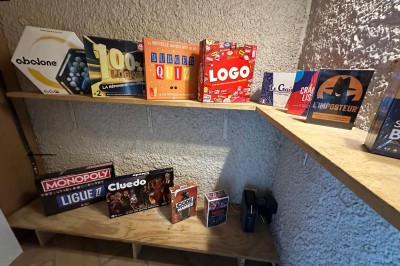 Escalier en bois avec rambarde, dans un intérieur aux murs blancs texturés et sol en carrelage.