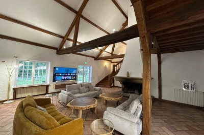 Escalier en bois avec rambarde, dans un intérieur aux murs blancs texturés et sol en carrelage.