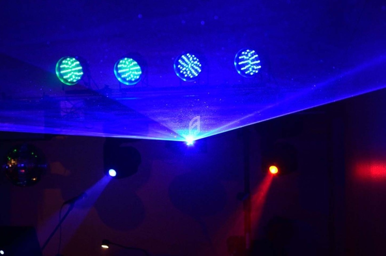 Jeux de lumières colorées projetés dans une pièce sombre, avec faisceaux bleus, rouges et verts.