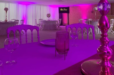 Terrain de pétanque intérieur avec sol en sable, encadré de murs en tôle et briques, à côté d'un espace détente.