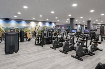 Bornes de recharge électrique Tesla alignées dans un parking, entourées de verdure en arrière-plan.