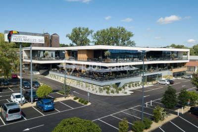 Bornes de recharge électrique Tesla alignées dans un parking, entourées de verdure en arrière-plan.