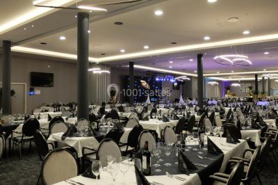 Bornes de recharge électrique Tesla alignées dans un parking, entourées de verdure en arrière-plan.