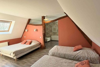 Des personnes discutent debout autour de tables en bois devant des tentes blanches dans un espace extérieur arboré.