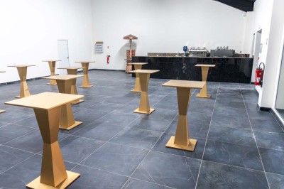 Cuisine professionnelle moderne avec équipements en inox, éclairage suspendu et fourneaux sous une hotte d'extraction.