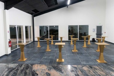 Cuisine professionnelle moderne avec équipements en inox, éclairage suspendu et fourneaux sous une hotte d'extraction.