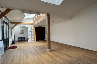 Cuisine moderne avec évier, machine à café automatique, bouilloire et étagères murales décorées.