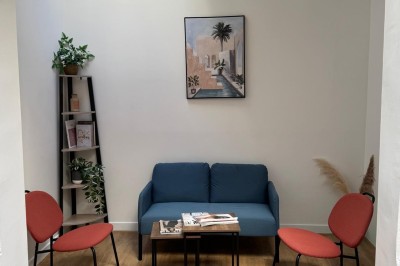 Cuisine moderne avec évier, machine à café automatique, bouilloire et étagères murales décorées.