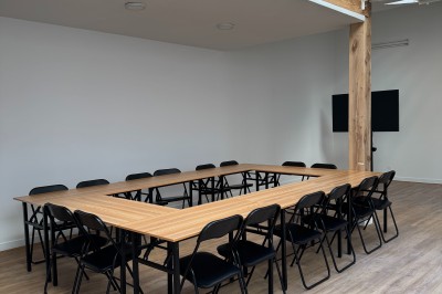 Intérieur d'une pièce lumineuse avec parquet, poutres en bois, verrière et mezzanine.