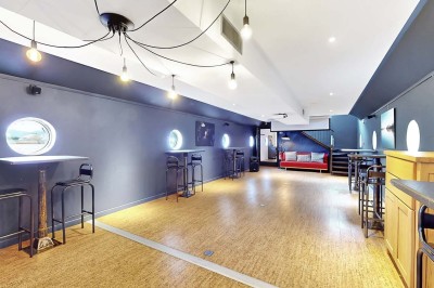 Miniature Location salle Tain-l'Hermitage (Drôme) - La Péniche #7 Terrasse en bois avec tables et chaises pliantes roses sous de grands parasols, entourée de plantes vertes.