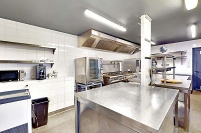 Miniature Location salle Tain-l'Hermitage (Drôme) - La Péniche #5 Terrasse ensoleillée avec tables et chaises pliantes roses sous de grands parasols, entourée de plantes vertes.