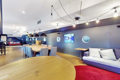 Miniature Location salle Tain-l'Hermitage (Drôme) - La Péniche #6 Terrasse ensoleillée avec tables et chaises pliantes roses sous de grands parasols, entourée de plantes vertes.