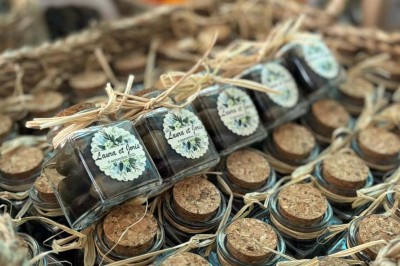 Chaises blanches alignées en extérieur face à une arche décorée, avec vue sur un paysage vallonné et des arbres.