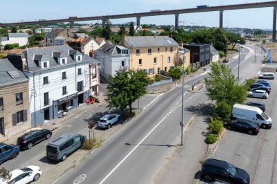 Vue aérienne d'un fleuve traversé par un pont, entouré de zones industrielles et d'infrastructures portuaires.