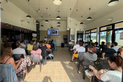 Cuisine professionnelle équipée d'un four à double étage, de deux friteuses et de plans de travail en inox.