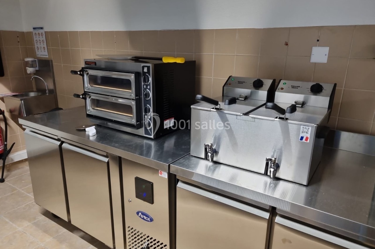 Équipements de cuisine professionnelle comprenant un four à double compartiment et deux friteuses sur un plan de travail en…