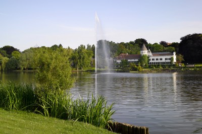 Miniature Location salle Rixensart (Brabant wallon) - Martin's Château du Lac #2 Femme allongée recevant un soin du visage avec un bandeau blanc, une personne nettoie sa peau avec des cotons.