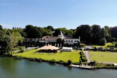 Miniature Location salle Rixensart (Brabant wallon) - Martin's Château du Lac #6 Femme allongée recevant un soin du visage avec un bandeau blanc, une personne nettoie sa peau avec des cotons.