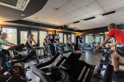 Miniature Location salle Rixensart (Brabant wallon) - Martin's Château du Lac #15 Femme allongée recevant un soin du visage avec un bandeau blanc, une personne nettoie sa peau avec des cotons.