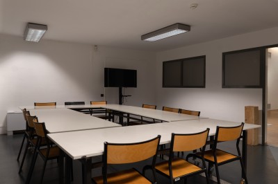 Miniature Location salle Bègles (Gironde) - La Salle Bolieu #2 Salle vide avec parquet en bois, murs blancs, écran de projection et plafond industriel avec éclairage suspendu.