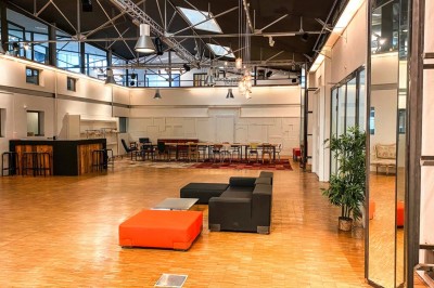 Miniature Location salle Bègles (Gironde) - La Salle Bolieu #6 Salle vide avec parquet en bois, murs blancs, écran de projection et plafond industriel avec éclairage suspendu.